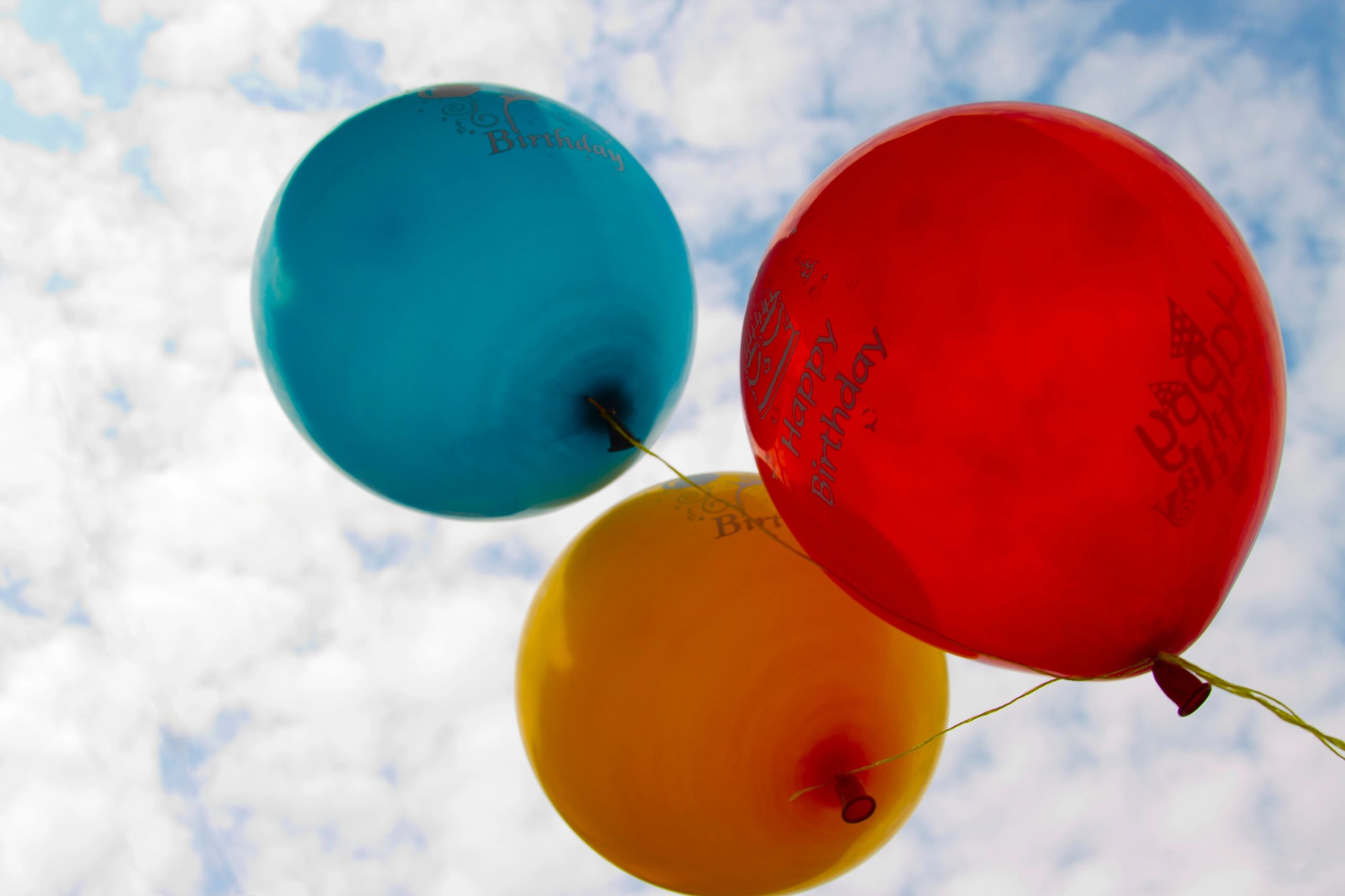 Floating balloons against sky background