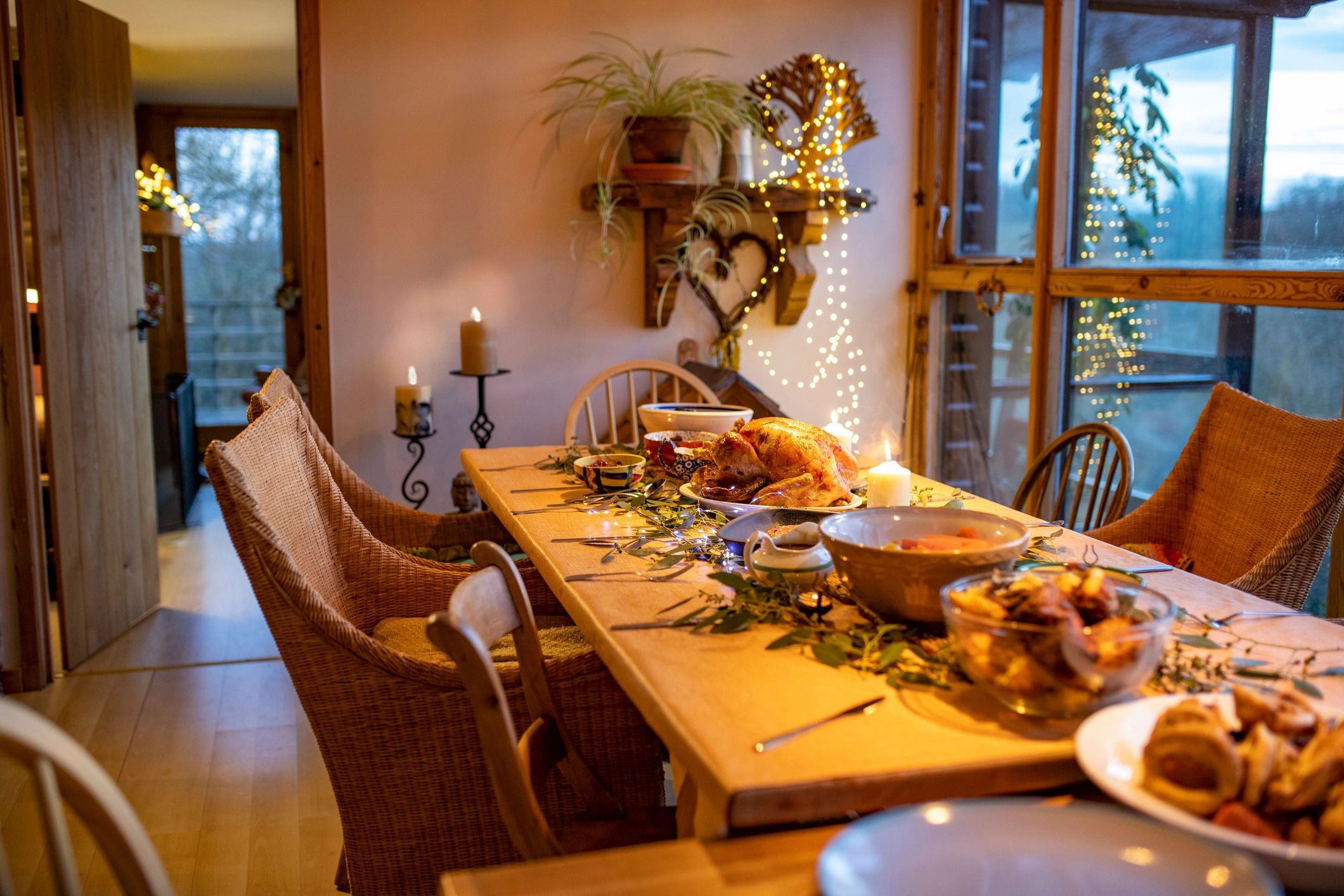 Candlelit holiday table styled with greenery and warm neutral accents