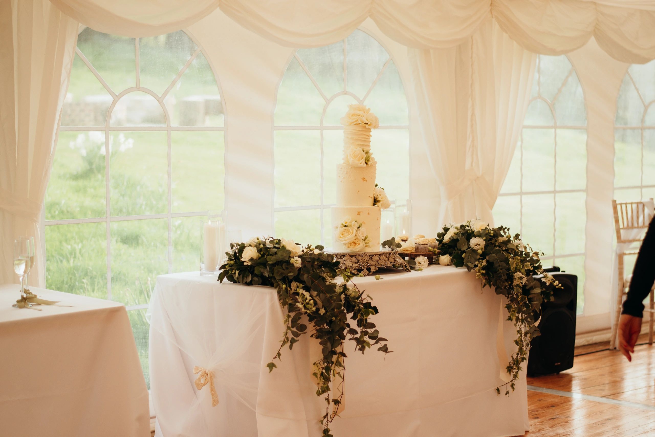 Three-tier cake styled in a neutral palette at an elegant reception